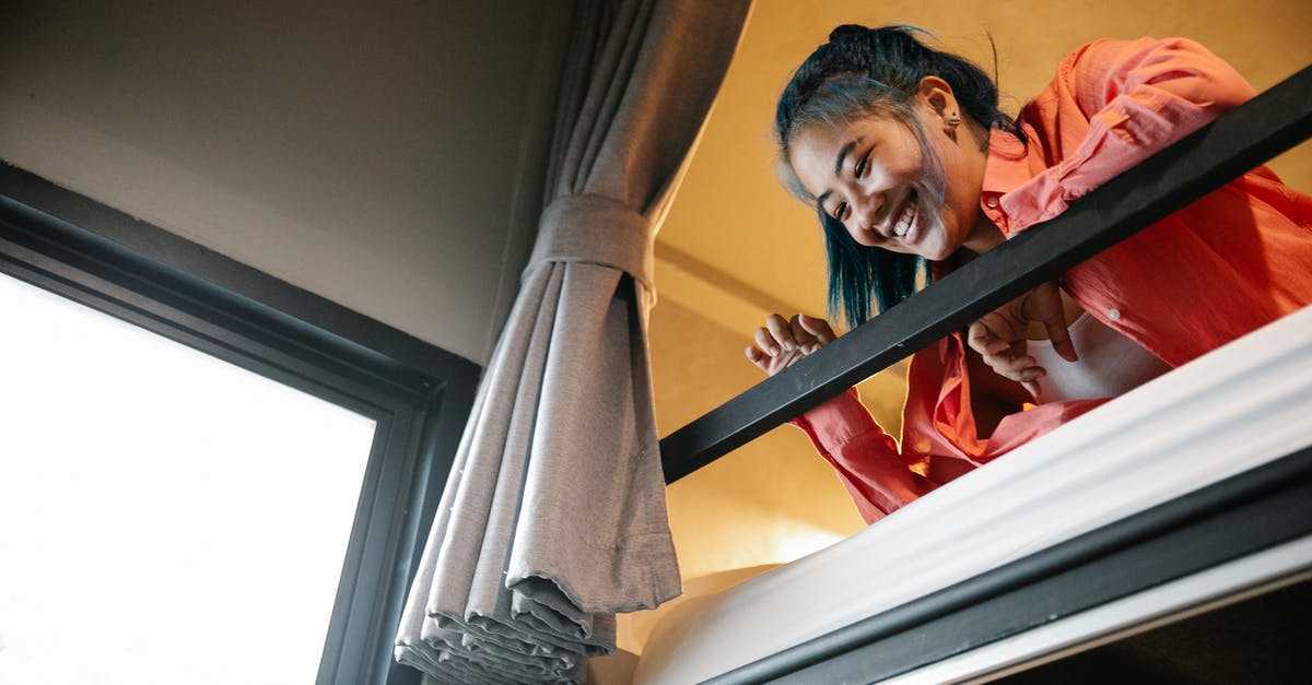 Is it possible to buy a travel curtain for hostels/trains? - Low angle of young ethnic cheerful female resting on bunk bed and looking down from top tier of bed near window with curtain Is it possible to buy a travel curtain for hostels/trains? - Low angle of young ethnic cheerful female resting on bunk bed and looking down from top tier of bed near window with curtain