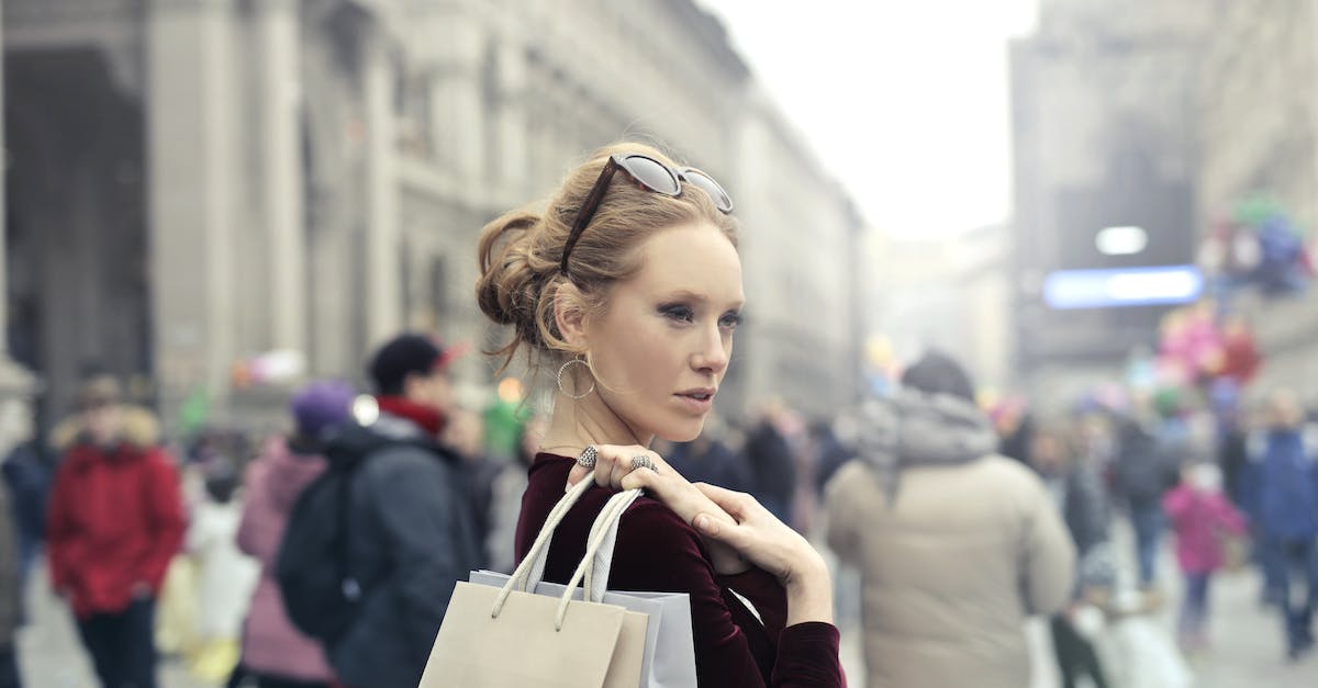 Is it possible to buy outdoor clothing in Northern India/Nepal? - Woman Wearing Maroon Long-sleeved Top Carrying Brown and White Paper Bags in Selective Focus Photography