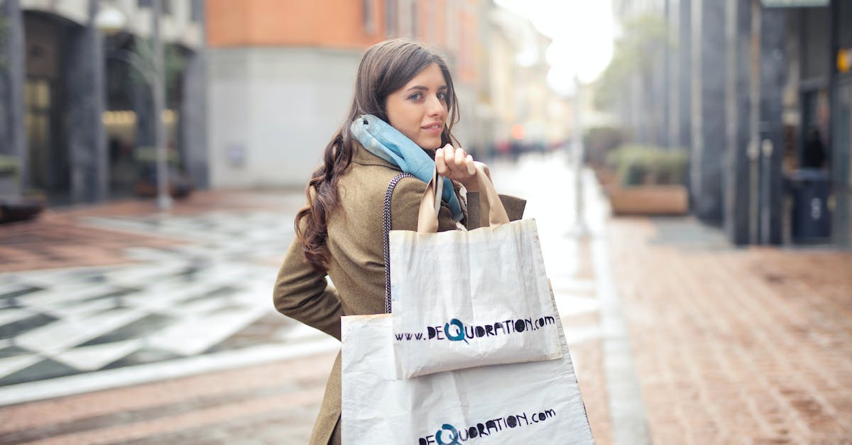 Is it possible to buy outdoor clothing in Northern India/Nepal? - Woman in Brown Coat Carrying Two White Tote Bags