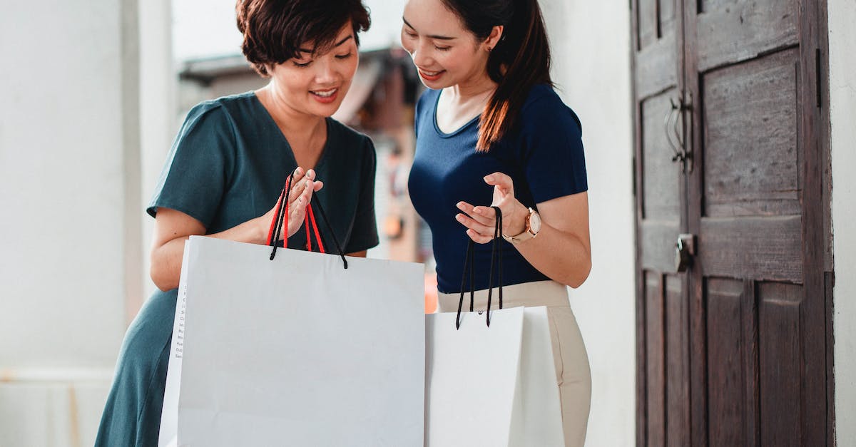 Is it possible to buy outdoor clothing in Northern India/Nepal? - Happy ethnic women holding paper bags after shopping and showing purchases to each other