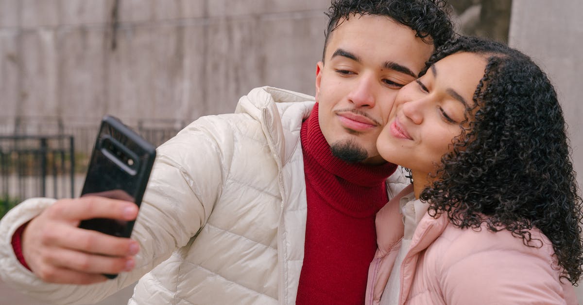 Is it possible to change date of a connection? - Enamored young Hispanic couple in warm casual clothes smiling and touching cheeks while taking selfie on mobile phone standing on street Is it possible to change date of a connection? - Enamored young Hispanic couple in warm casual clothes smiling and touching cheeks while taking selfie on mobile phone standing on street