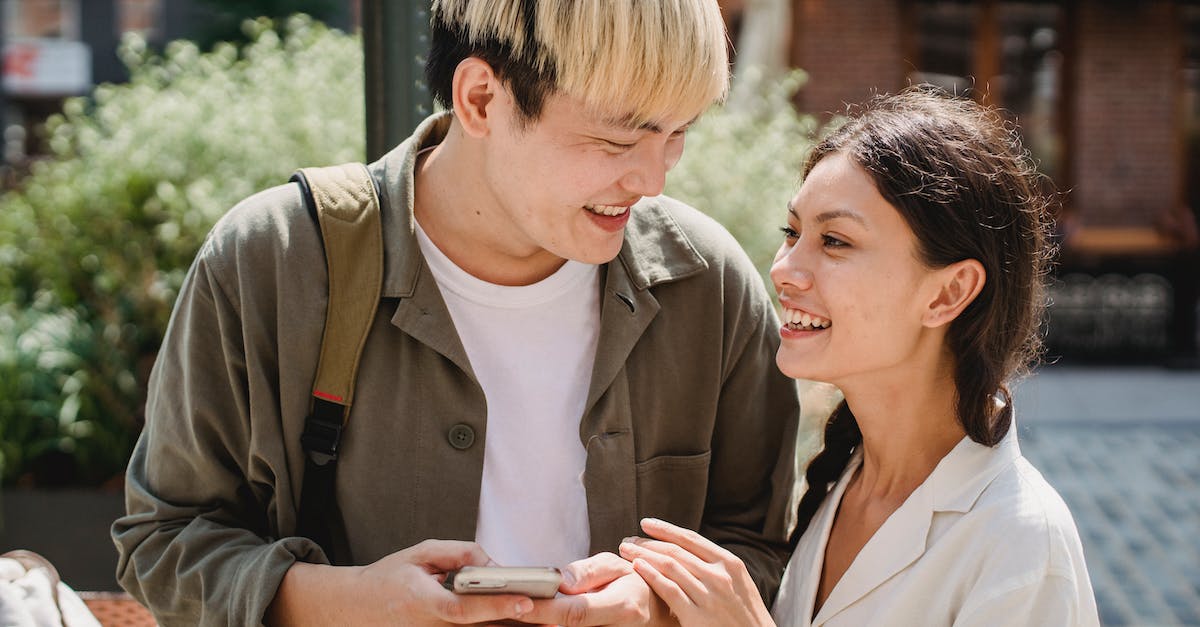 Is it possible to change date of a connection? - Positive young multiethnic couple smiling and looking at each other on street Is it possible to change date of a connection? - Positive young multiethnic couple smiling and looking at each other on street