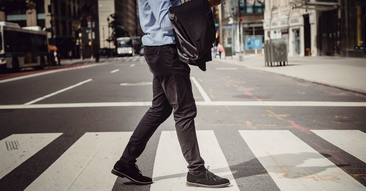 Is it possible to cross Switzerland without using a vignette? - Crop stylish man walking on crosswalk in downtown Is it possible to cross Switzerland without using a vignette? - Crop stylish man walking on crosswalk in downtown