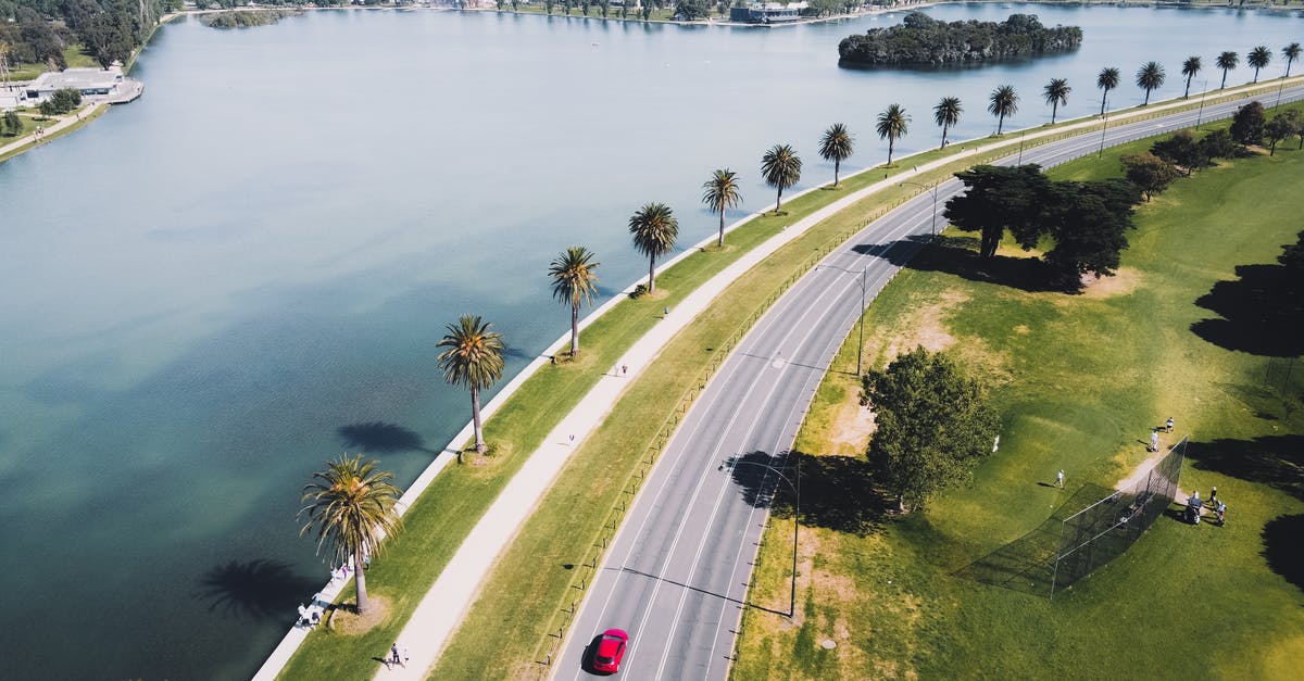 Is it possible to enter Australia with a temporary Polish passport? - Cars on Road Near Green Trees and Body of Water