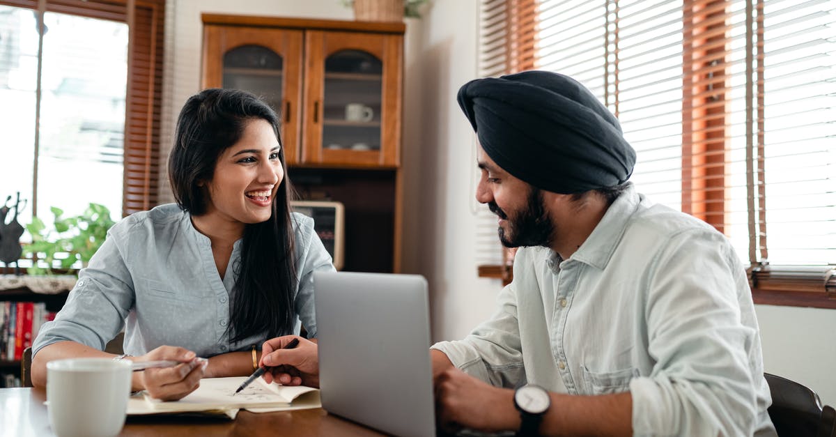 Is it possible to extend an Indian business visa from India? - Laughing Indian woman with husband sitting at table and discussing project while working together with laptop and notebook at home Is it possible to extend an Indian business visa from India? - Laughing Indian woman with husband sitting at table and discussing project while working together with laptop and notebook at home