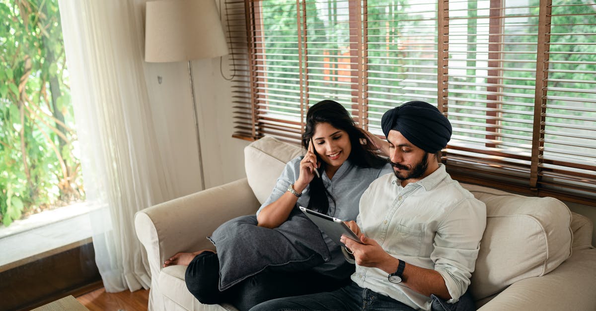 Is it possible to extend an Indian business visa from India? - Side view of positive young Sikh man in shirt and turban working on laptop at home while wife leaning on chair behind Is it possible to extend an Indian business visa from India? - Side view of positive young Sikh man in shirt and turban working on laptop at home while wife leaning on chair behind