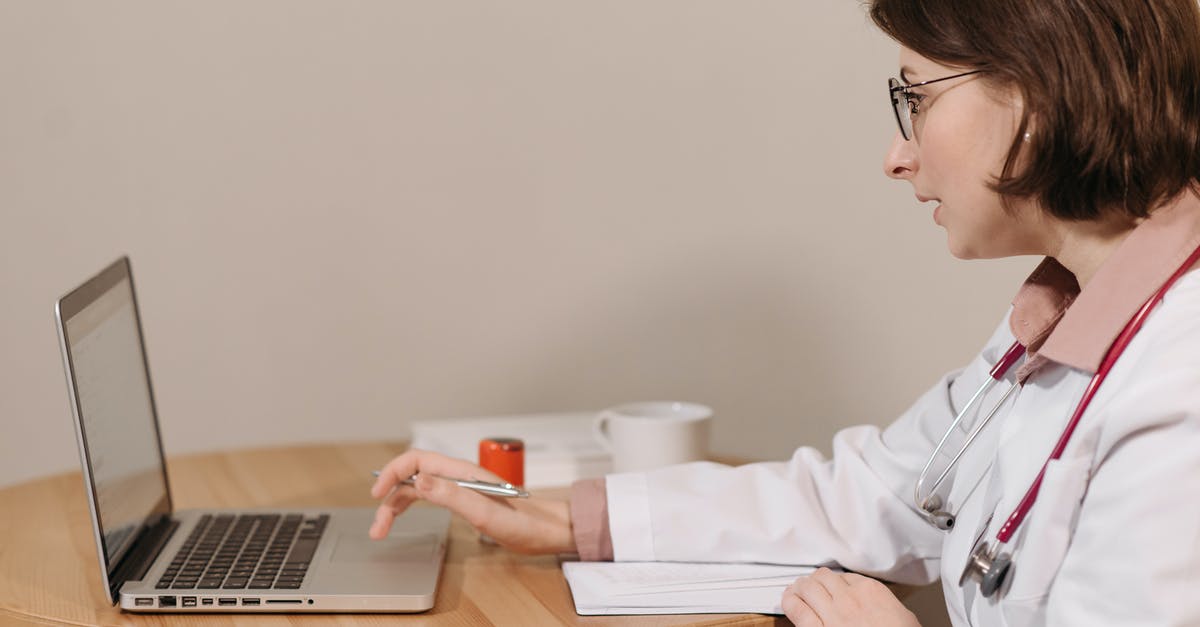 Is it possible to get a prescription in the United States while abroad using an online medical service? - Physician in White Coat Using Her Laptop