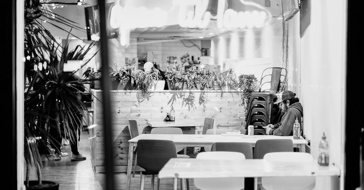 Is it possible to go through the Ryanair visa check ahead of time? - Black and white of bearded young male surfing internet of mobile phone at table in cafe with potted plants Is it possible to go through the Ryanair visa check ahead of time? - Black and white of bearded young male surfing internet of mobile phone at table in cafe with potted plants