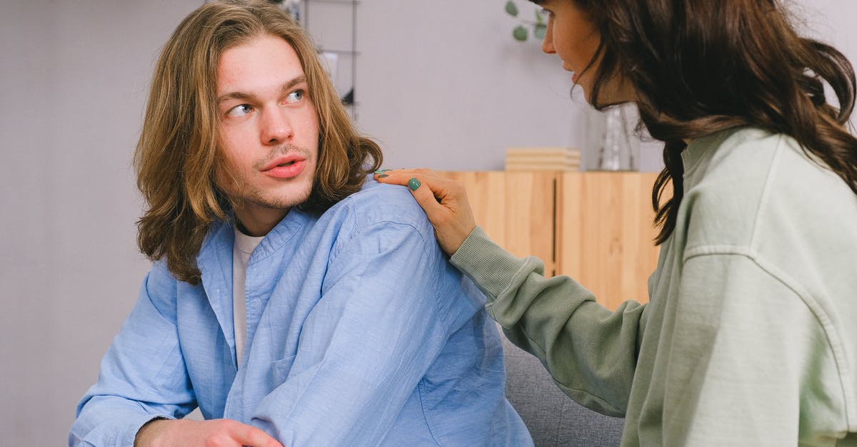 Is it possible to share an individual hotel room? - Concentrated woman talking and touching shoulder of pensive male in light room in daytime Is it possible to share an individual hotel room? - Concentrated woman talking and touching shoulder of pensive male in light room in daytime