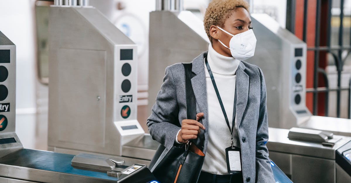 Is it possible to use the JR Pass at these stations in Tokyo? - Calm attractive African American female in stylish formal wear and protective mask passing through turnstile gates in underground station Is it possible to use the JR Pass at these stations in Tokyo? - Calm attractive African American female in stylish formal wear and protective mask passing through turnstile gates in underground station