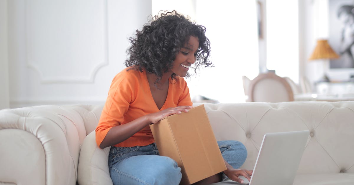 Is it risky to send a copy of my Passport to someone I only know online? [duplicate] - Side view of smiling African American lady in casual clothes holding box while sitting on sofa and browsing laptop