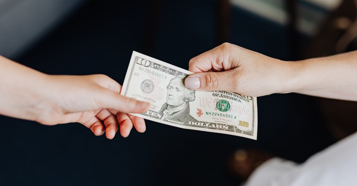 Is it rude to pay tips in Iran? - Hands Holding a 10 Dollar Bill Is it rude to pay tips in Iran? - Hands Holding a 10 Dollar Bill