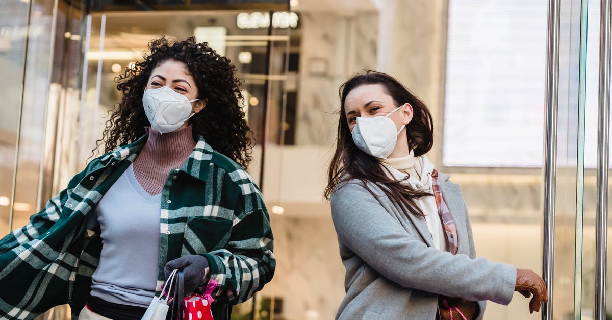 Is it safe to carry $10000? [closed] - Low angle of woman with purchases in colorful shopping bags walking through doors of store during coronavirus pandemic