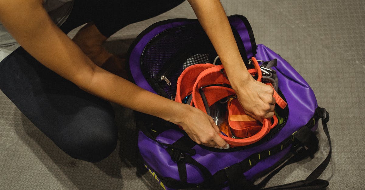 Is it safe to put a PS4 in checked luggage? - From above of crop anonymous female athlete sitting on floor and packing safety belt in bag after training in contemporary gym Is it safe to put a PS4 in checked luggage? - From above of crop anonymous female athlete sitting on floor and packing safety belt in bag after training in contemporary gym