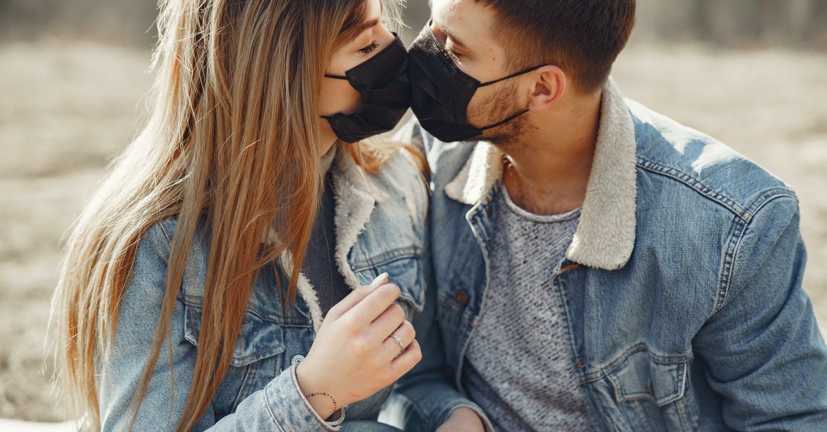 Is it safe to visit Nepal during the outbreak of COVID-19? [closed] - Loving young couple kissing while wearing black medical masks
