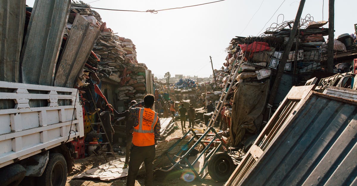 Is my passport damaged and can't be used for traveling? - Unrecognizable workmen standing near pile of metal scrap in dump Is my passport damaged and can't be used for traveling? - Unrecognizable workmen standing near pile of metal scrap in dump