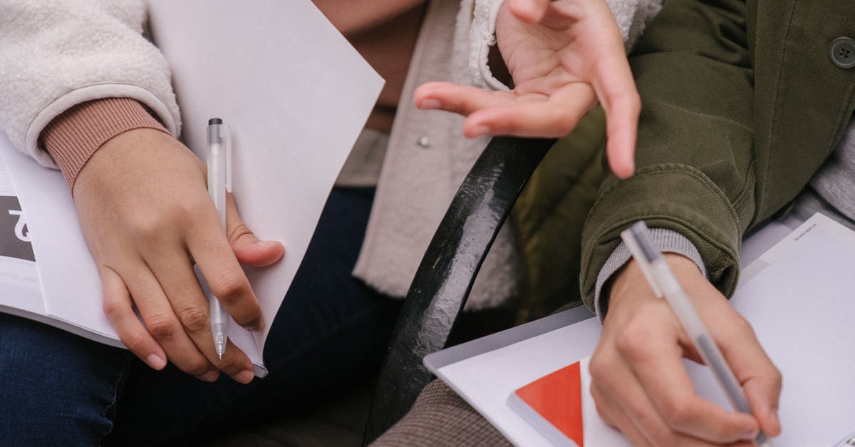 is my visa gonna be checked at point B b4 c [closed] - From above of crop anonymous student couple in casual wear sitting together on bench and discussing preparing homework at daytime