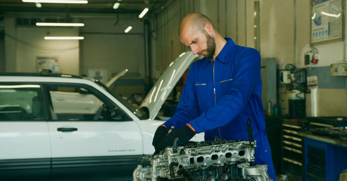 Is not checking in any baggage suspicious? - A Man in Blue Uniform Repairing an Engine Is not checking in any baggage suspicious? - A Man in Blue Uniform Repairing an Engine