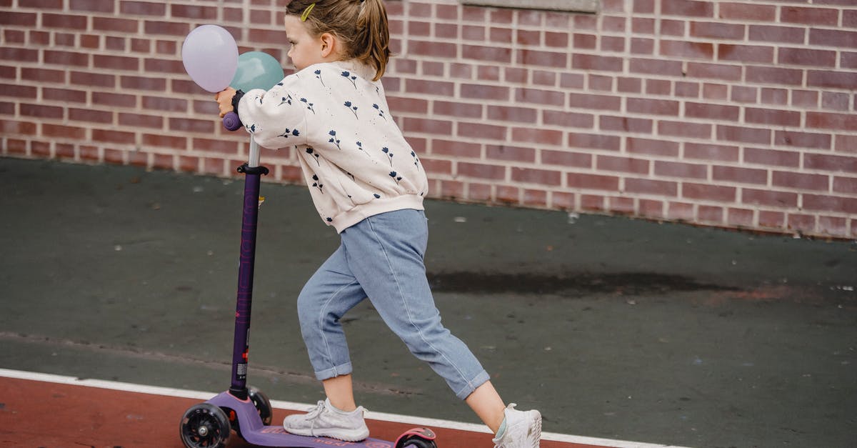 Is riding an electric scooter on pavement not tolerated in London? [closed] - Girl with balloons riding scooter on sports ground