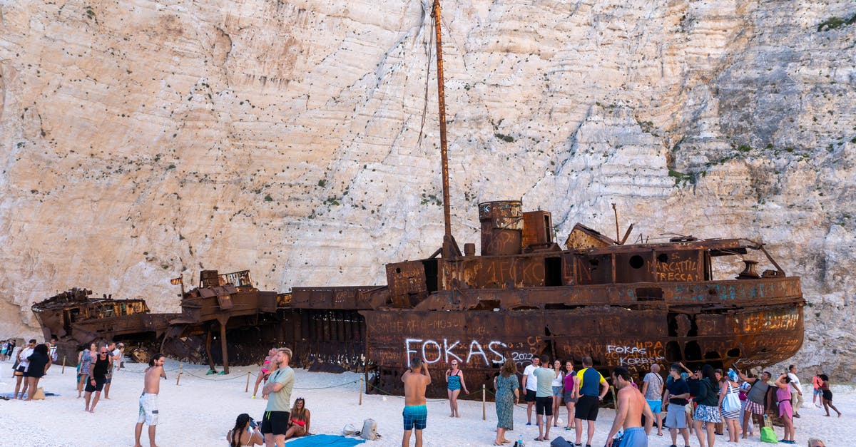 Is sleeping in tents allowed in Shipwreck Beach (Navagio) in Zante, Greece? - Shipwreck ]People on the Beach with a Shipwrecked
