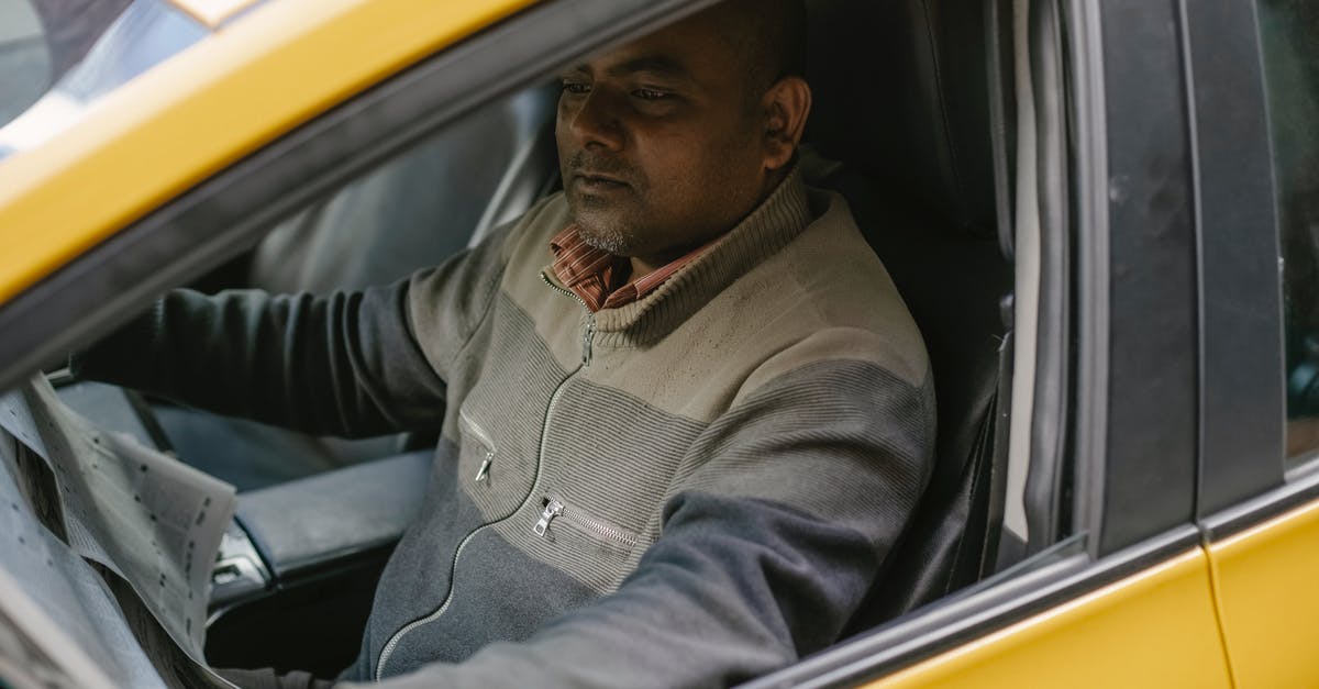 Is there a 'minimum daily spend' in Bhutan, and does it vary on citizenship? - Ethnic male driver reading daily newspaper with interest while sitting in car and having break Is there a 'minimum daily spend' in Bhutan, and does it vary on citizenship? - Ethnic male driver reading daily newspaper with interest while sitting in car and having break