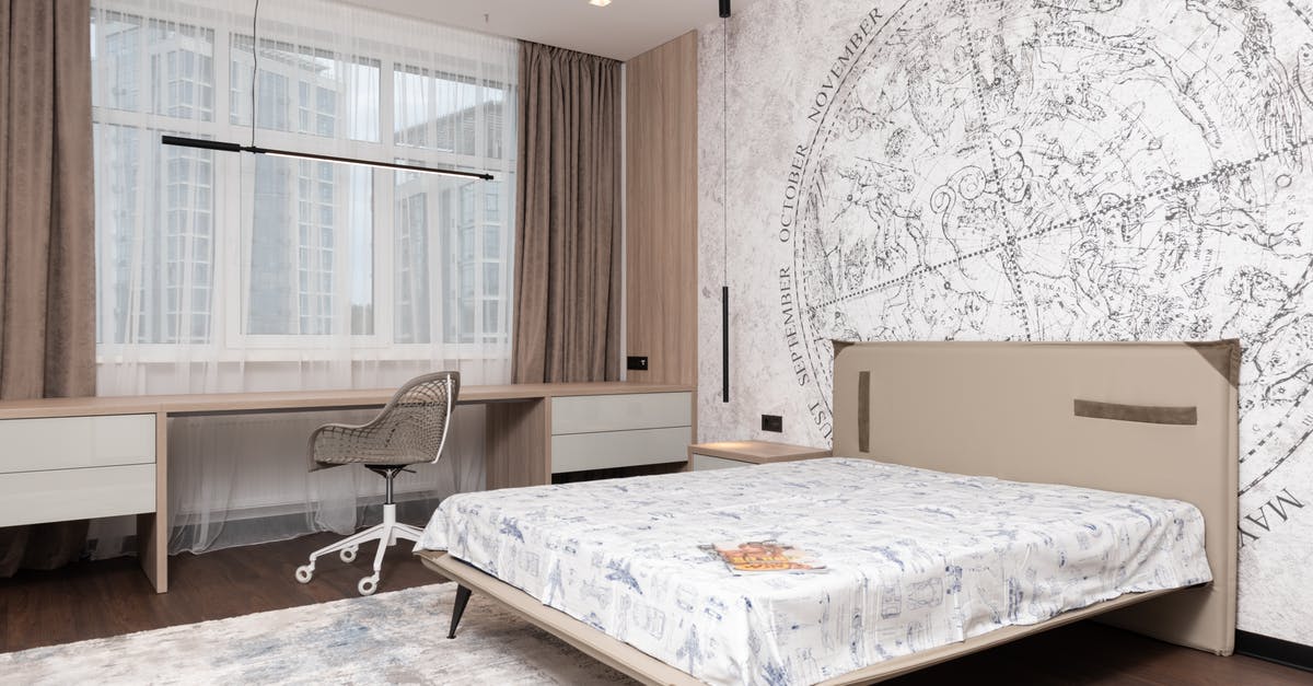 Is there a hotel booking website that lets you filter by a highlighted map area? - Modern room with wide bed under map on wall and long table with comfortable chair Is there a hotel booking website that lets you filter by a highlighted map area? - Modern room with wide bed under map on wall and long table with comfortable chair