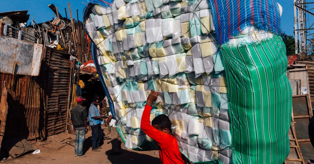 Is there a liability limit for a carry-on bag that was forcibly checked plane-side? - Side view of anonymous ethnic male in casual wear carrying heavy stack of merchandise with striped bags on dry terrain under blue sky in sunlight Is there a liability limit for a carry-on bag that was forcibly checked plane-side? - Side view of anonymous ethnic male in casual wear carrying heavy stack of merchandise with striped bags on dry terrain under blue sky in sunlight