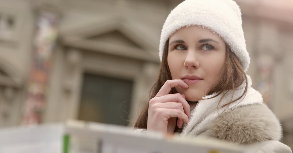 Is there a map that shows Austrian winter road closures? - Concentrated female in warm hat and coat looking for right way while standing with map in street Is there a map that shows Austrian winter road closures? - Concentrated female in warm hat and coat looking for right way while standing with map in street