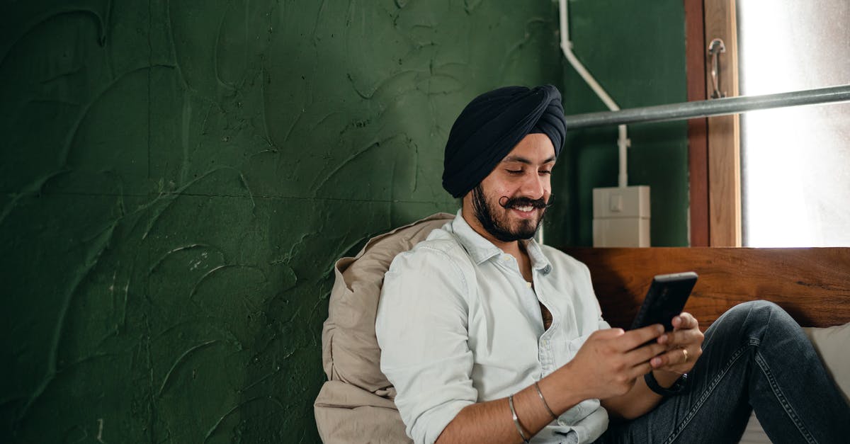 Is there a possibility to preserve an unused Indian mobile number for a period of time? - Smiling man in turban using smartphone while relaxing at home Is there a possibility to preserve an unused Indian mobile number for a period of time? - Smiling man in turban using smartphone while relaxing at home