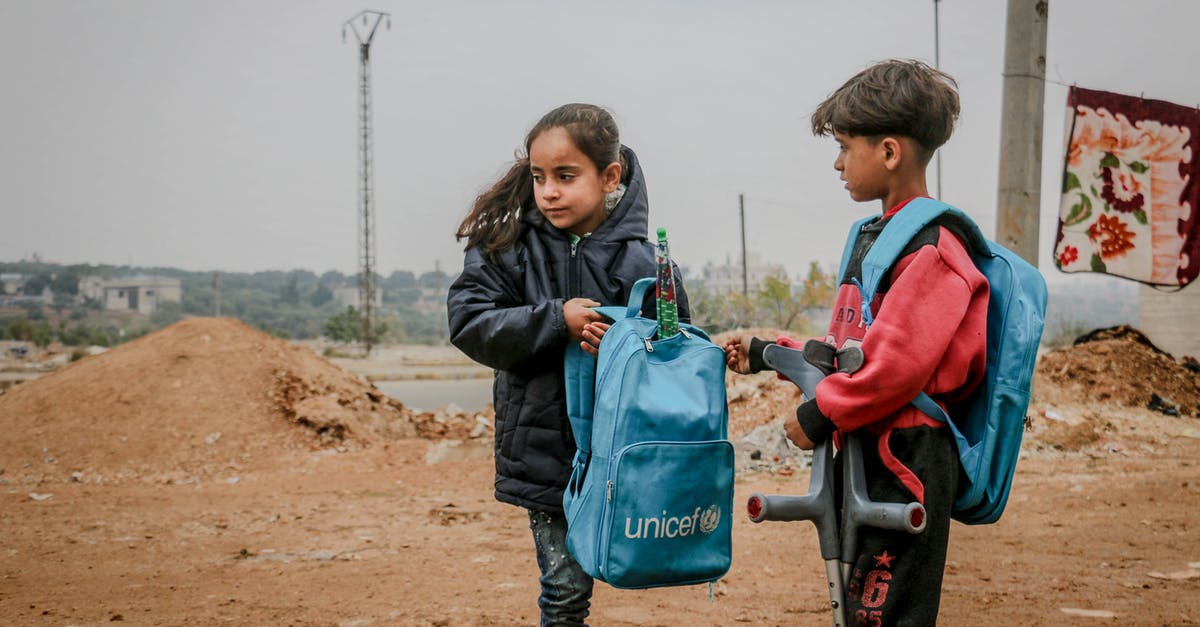 Is there a problem to use 2 passports, one for getting into country and another whilst coming back? [duplicate] - Poor ethnic children with crutches talking in rural areas under gloomy gray sky in daytime