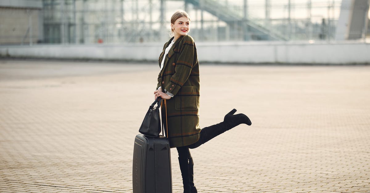 Is there a restaurant outside baggage claim, BOS Terminal E? - Full body of stylish female tourist in warm clothes and high heeled boots standing on background of blurred airport terminal with luggage and ladies bag