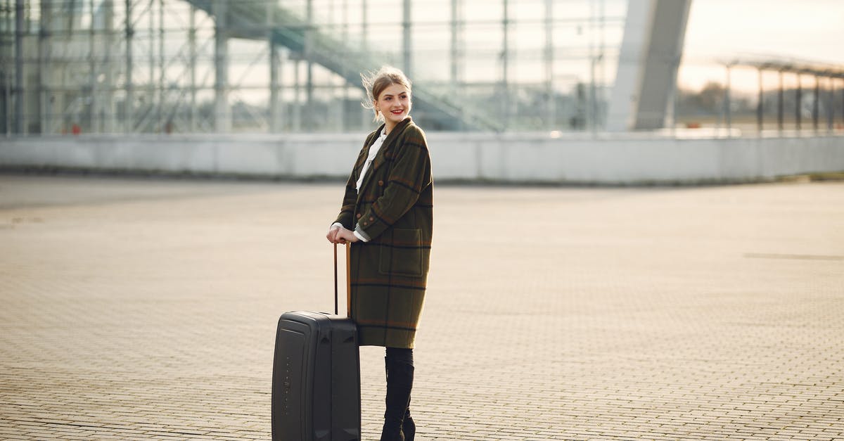 Is there a restaurant outside baggage claim, BOS Terminal E? - Cheerful female tourist with suitcase