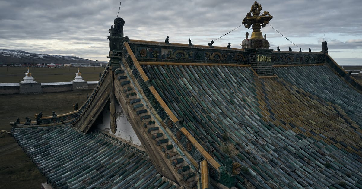 Is there a village in the mountains of central Asia that isn't very hot in August from where daytrips can be made without long drives? [closed] - From above of ancient Erdene Zuu Buddhist monastery with tiled roof and decorative roof elements under overcast sky in evening
