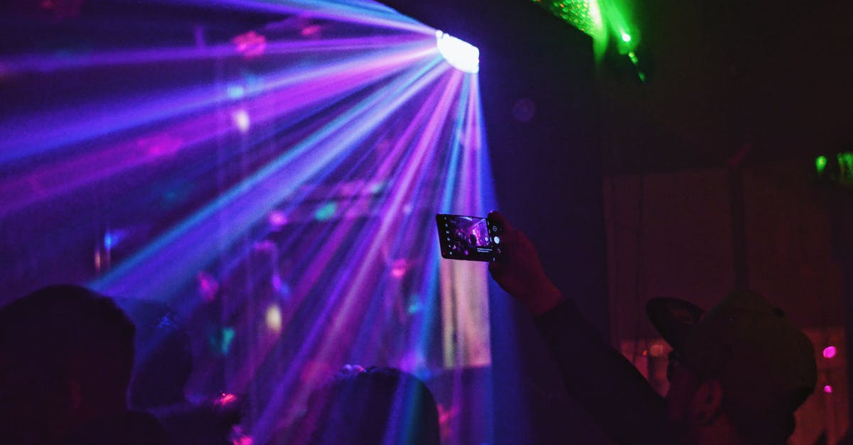 Is there an active nightlife in Seoul on weekdays? - Silhouettes of people in light of disco ball dancing in nightclub and man in cap taking photo Is there an active nightlife in Seoul on weekdays? - Silhouettes of people in light of disco ball dancing in nightclub and man in cap taking photo