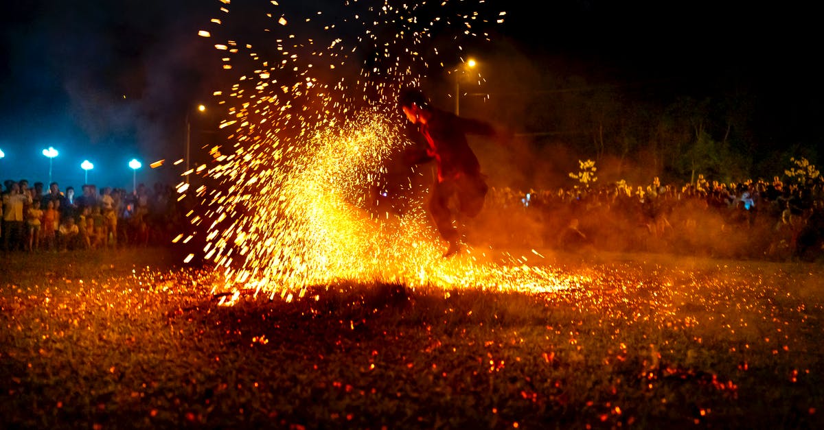 Is there an active nightlife in Seoul on weekdays? - Full body of male dancer performing dangerous movement with fire sparks at night among people Is there an active nightlife in Seoul on weekdays? - Full body of male dancer performing dangerous movement with fire sparks at night among people
