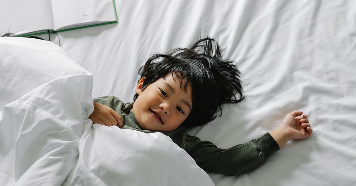 Is there an inexpensive way to get from Rovinj to Pula airport early in the morning in the offseason? - Ethnic boy lying in bed after sleep