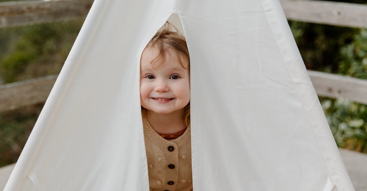 Is there an obligation to renew a small child's passport before its expiry date? - Happy little child smiling while peeking from tent