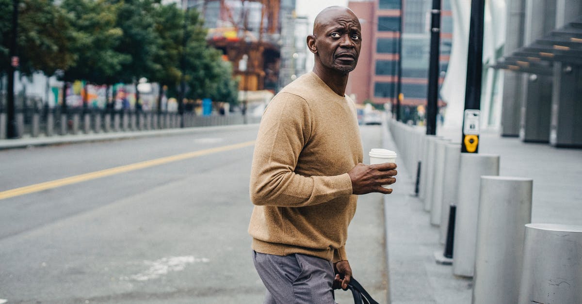 Is there any personal benefit in formally cancelling a (non-refundable) flight? - Formal black man with coffee on crosswalk