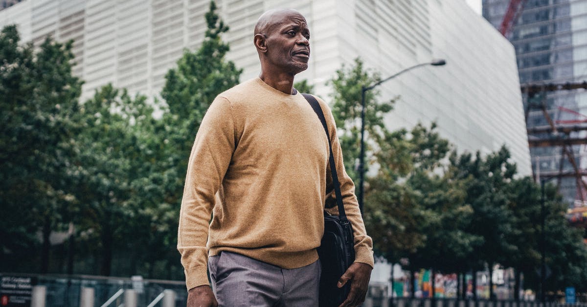 Is there any personal benefit in formally cancelling a (non-refundable) flight? - From below of adult African American businessman with personal bag walking in city center