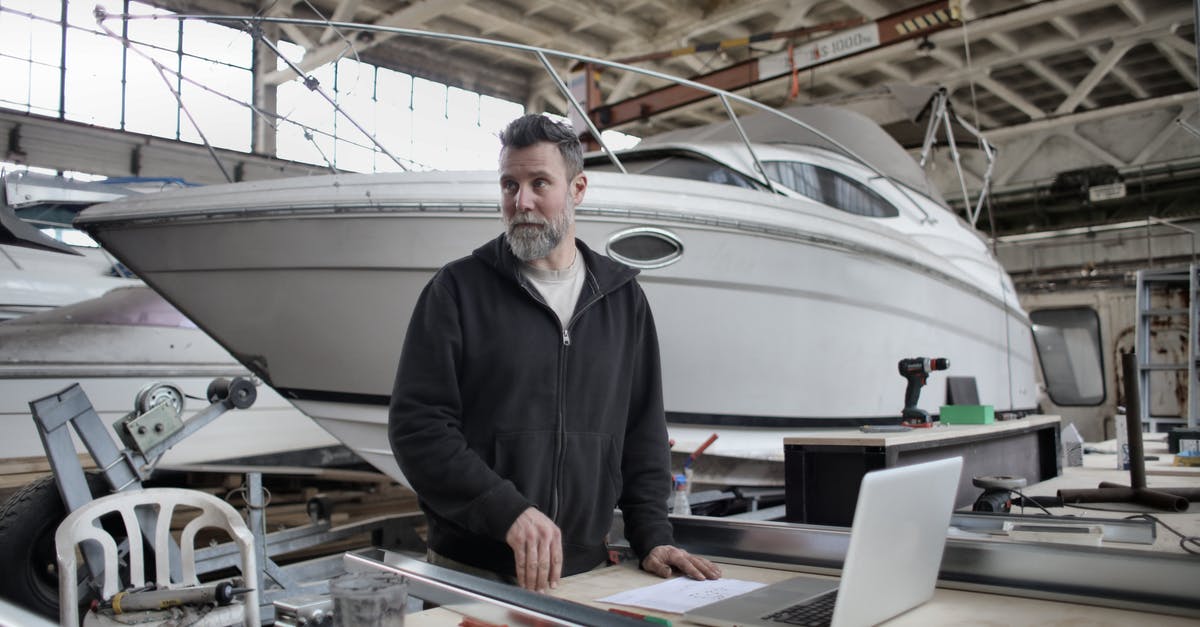 Is there any power plug that passengers may use on the Buquebus boat service between Buenos Aires and Montevideo? - Adult bearded man in casual clothes using laptop while working with metal details near boat in workshop and looking away Is there any power plug that passengers may use on the Buquebus boat service between Buenos Aires and Montevideo? - Adult bearded man in casual clothes using laptop while working with metal details near boat in workshop and looking away