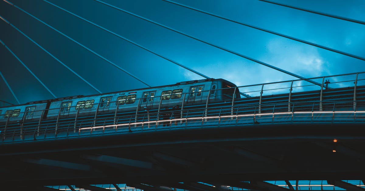 Is there any train from Germany to France where I can bring my car with me? - Train driving on city bridge under cloudy sky in evening Is there any train from Germany to France where I can bring my car with me? - Train driving on city bridge under cloudy sky in evening