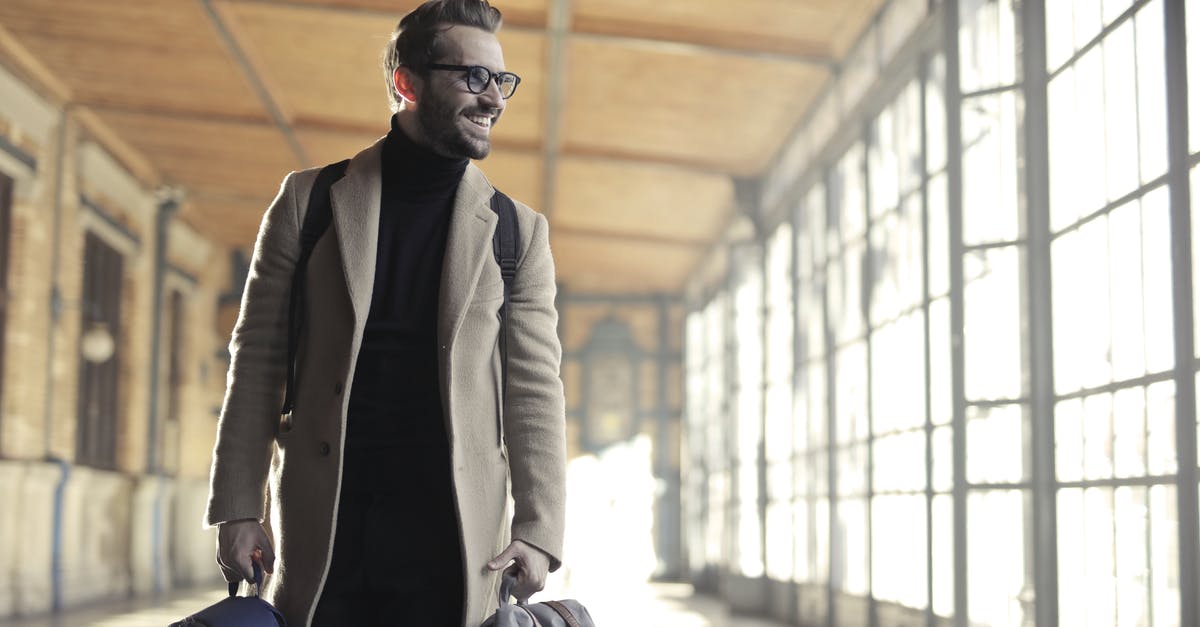 Is there luggage storage at train stations in Japan? - Man in Brown Robe Carrying Bag Smiling