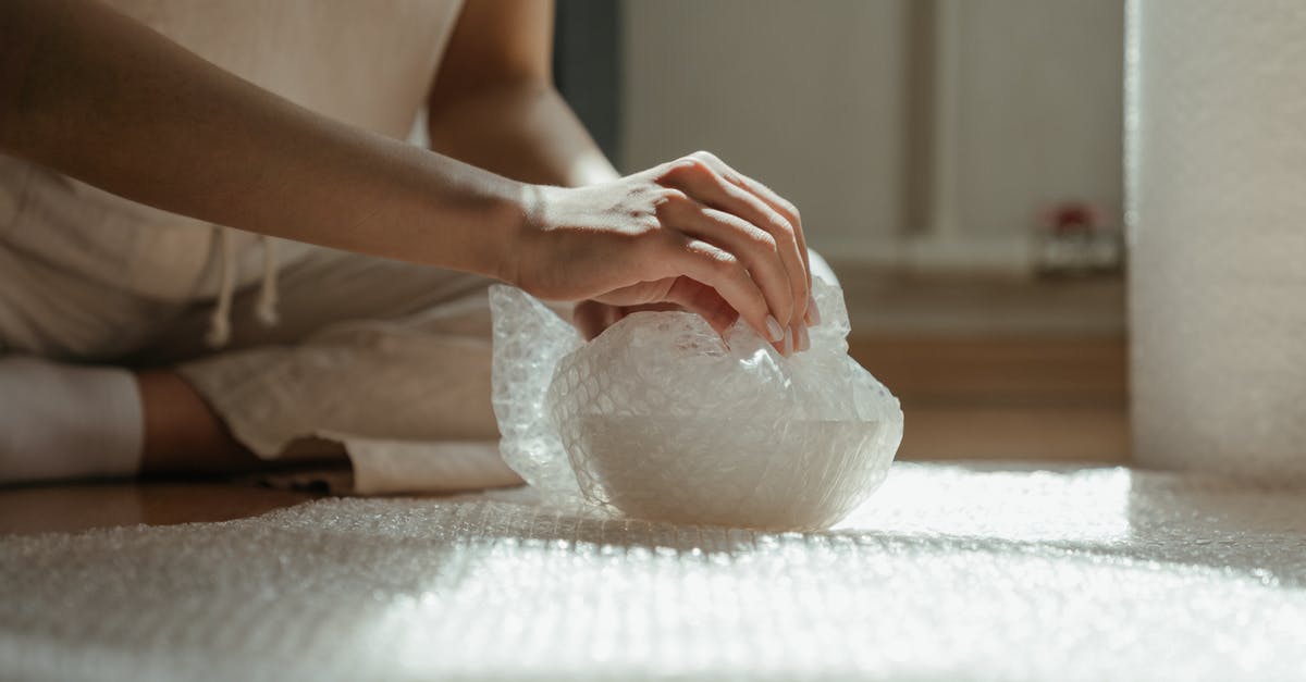 Is there plastic wrapping center at Stuttgart Airport? - Person Holding White Plastic Bag Is there plastic wrapping center at Stuttgart Airport? - Person Holding White Plastic Bag