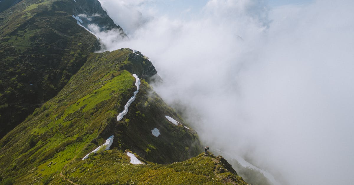 Is there snow in Sochi in summer? - Green Grass Covered Mountain Under White Clouds Is there snow in Sochi in summer? - Green Grass Covered Mountain Under White Clouds