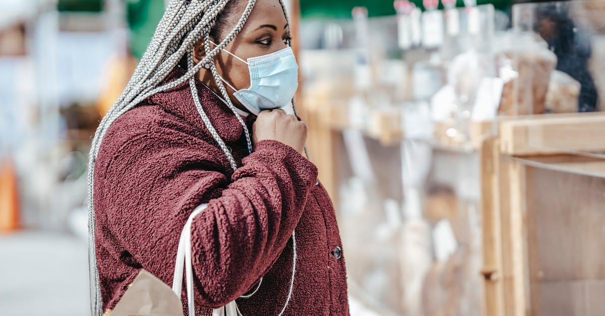 Is there somewhere I can store luggage (one or two normal suitcases) in San Francisco for a few days? - Black woman standing near pastry on market in mask