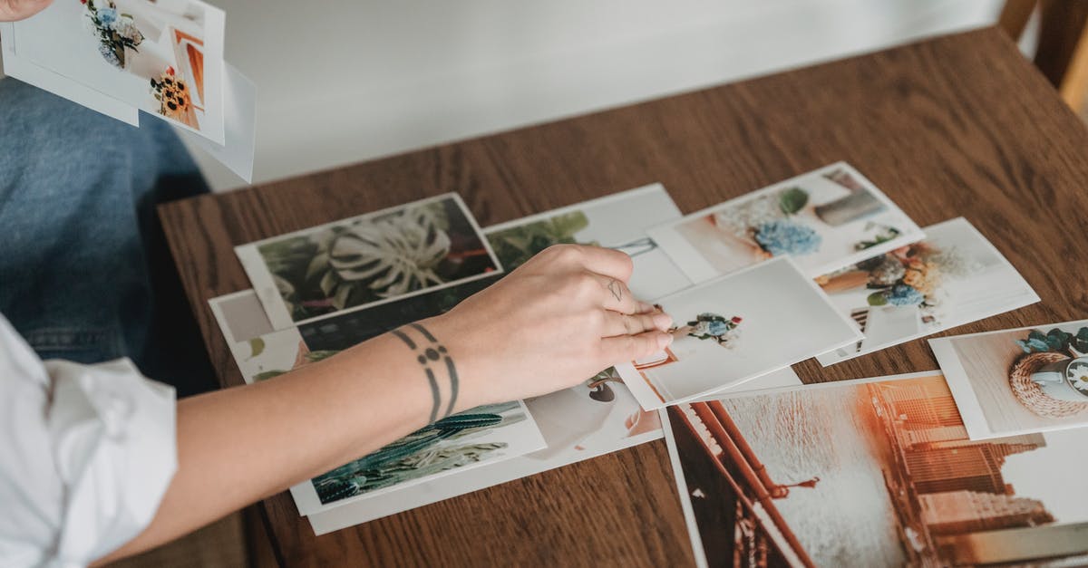 Is this airliner-shaped lake real? - Crop anonymous tattooed female with different photos of flowers and city at desk in house room Is this airliner-shaped lake real? - Crop anonymous tattooed female with different photos of flowers and city at desk in house room