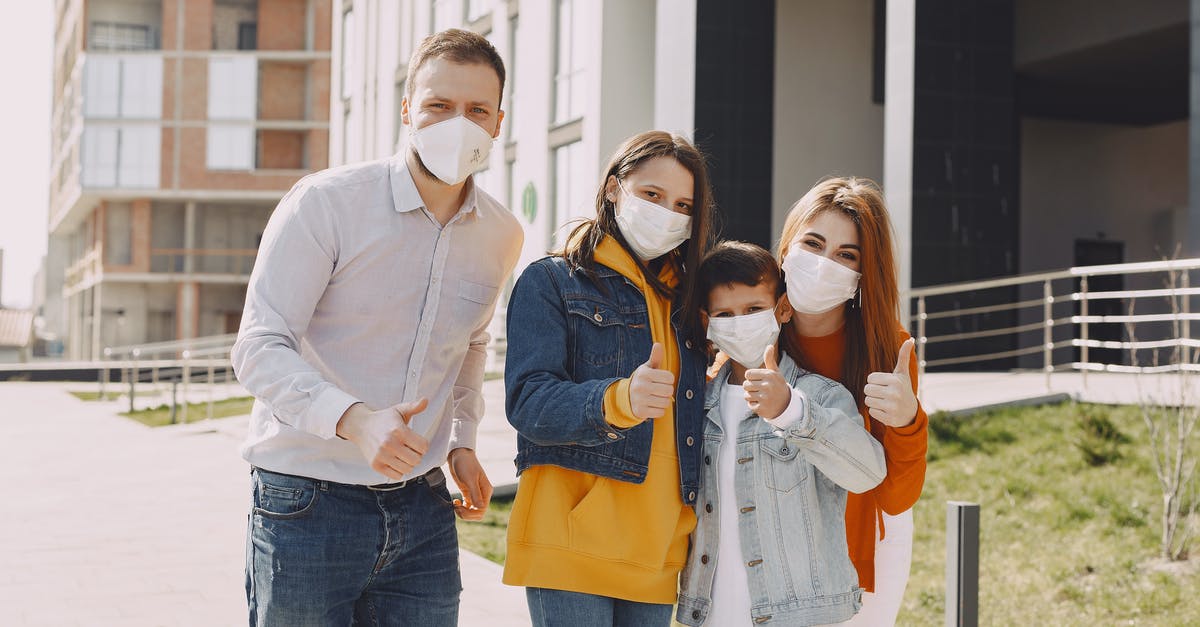 Is this area safe and good for tourists in Paris? [closed] - Optimistic family in protective masks and casual clothes standing together on street and showing thumbs up gesture while looking at camera