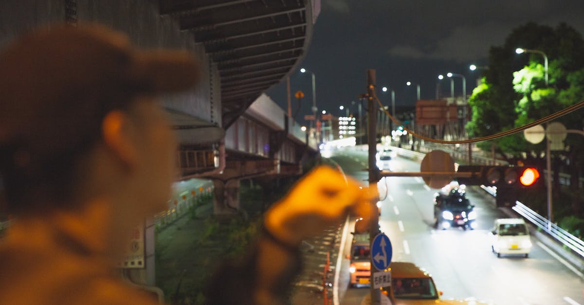 Is wearing perfume in public transports or rooms bad in Japan? - Man smoking and looking at traffic in city Is wearing perfume in public transports or rooms bad in Japan? - Man smoking and looking at traffic in city