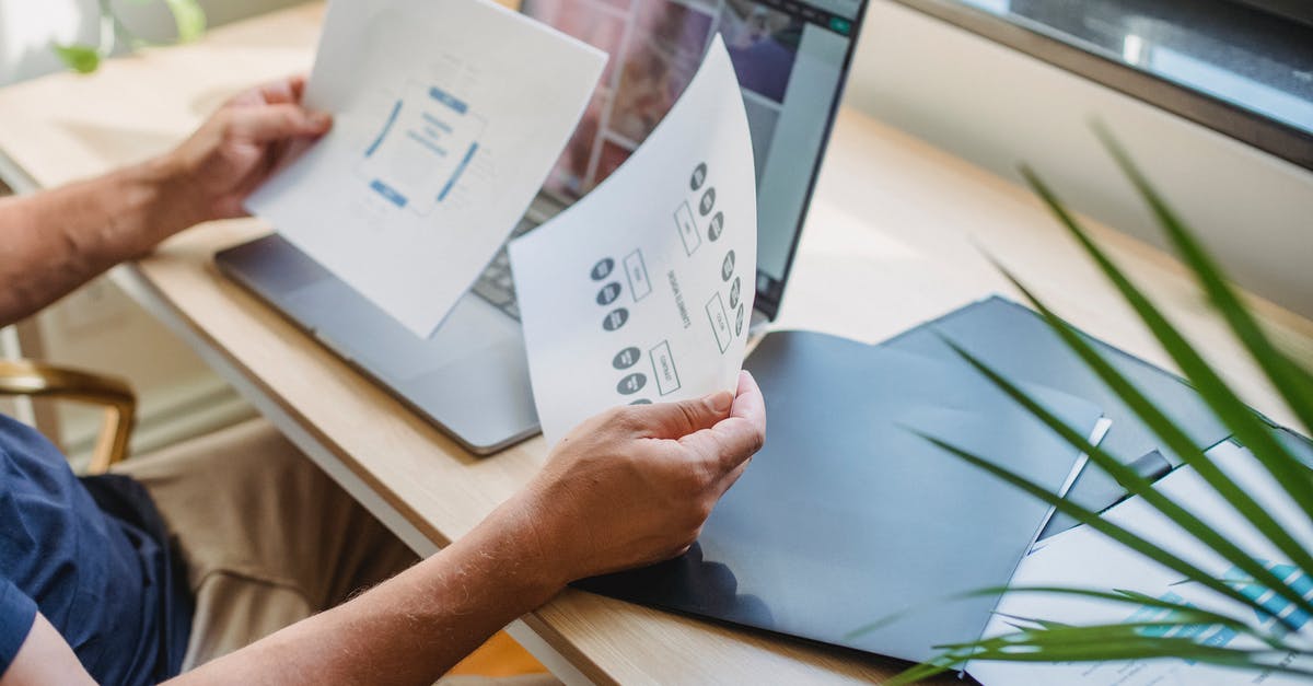 Is web check-in mandatory in German Wings? - Crop anonymous male designer in casual wear sitting at table with opened laptop and folders and reading papers Is web check-in mandatory in German Wings? - Crop anonymous male designer in casual wear sitting at table with opened laptop and folders and reading papers