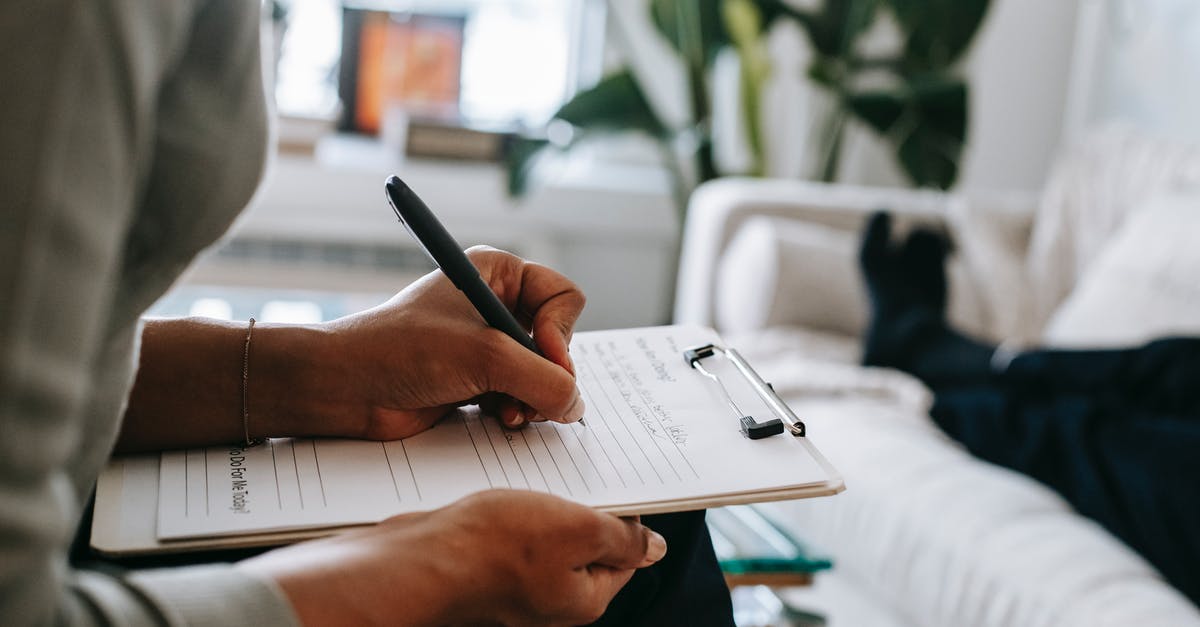 Issue regarding Schengen visa - Unrecognizable ethnic female therapist taking notes on clipboard while filling out form during psychological appointment with anonymous client lying on blurred background